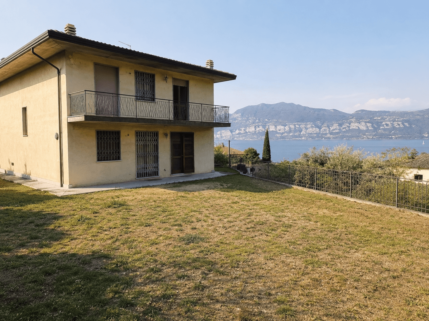 Casa a Bardolino prima dell'intervento: prato spelacchiato verso il lago di Garda